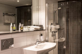 Handfat och dusch i badrum i master suite på Scandic Infra City